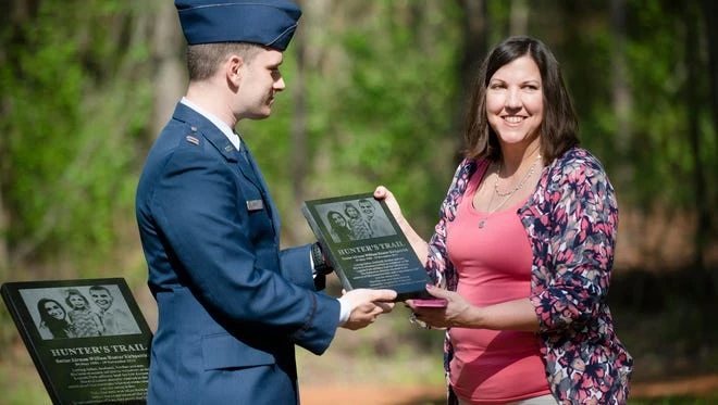 Capt. Adam Corley presents a plaque to Carole Kirkpatrick in honor of her son, Airman William Hunter Kirkpatrick, at Lagoon Park Trail on Monday, March 28, 2016, in Montgomery, Alabama.