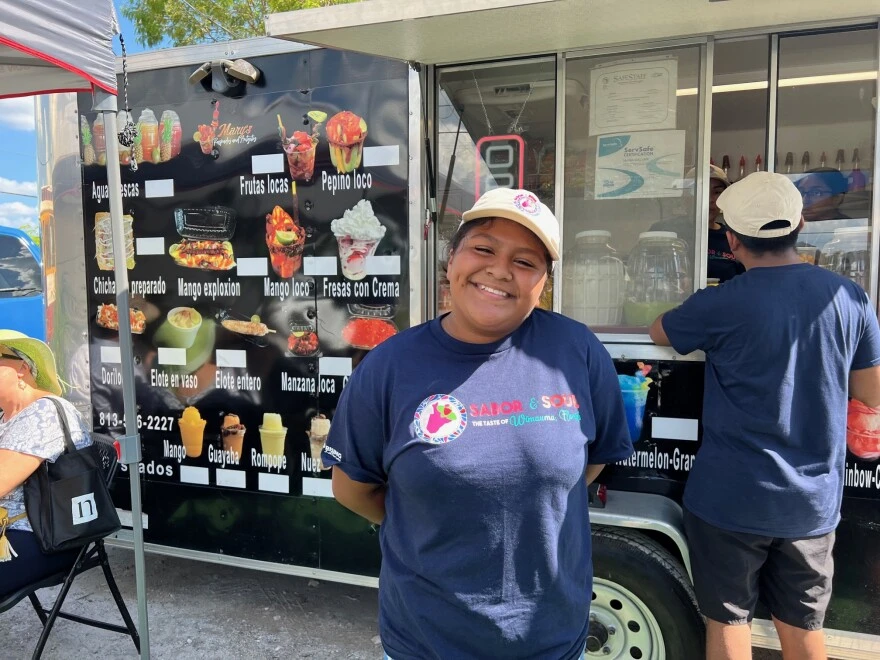 girl stands in front of a food truck