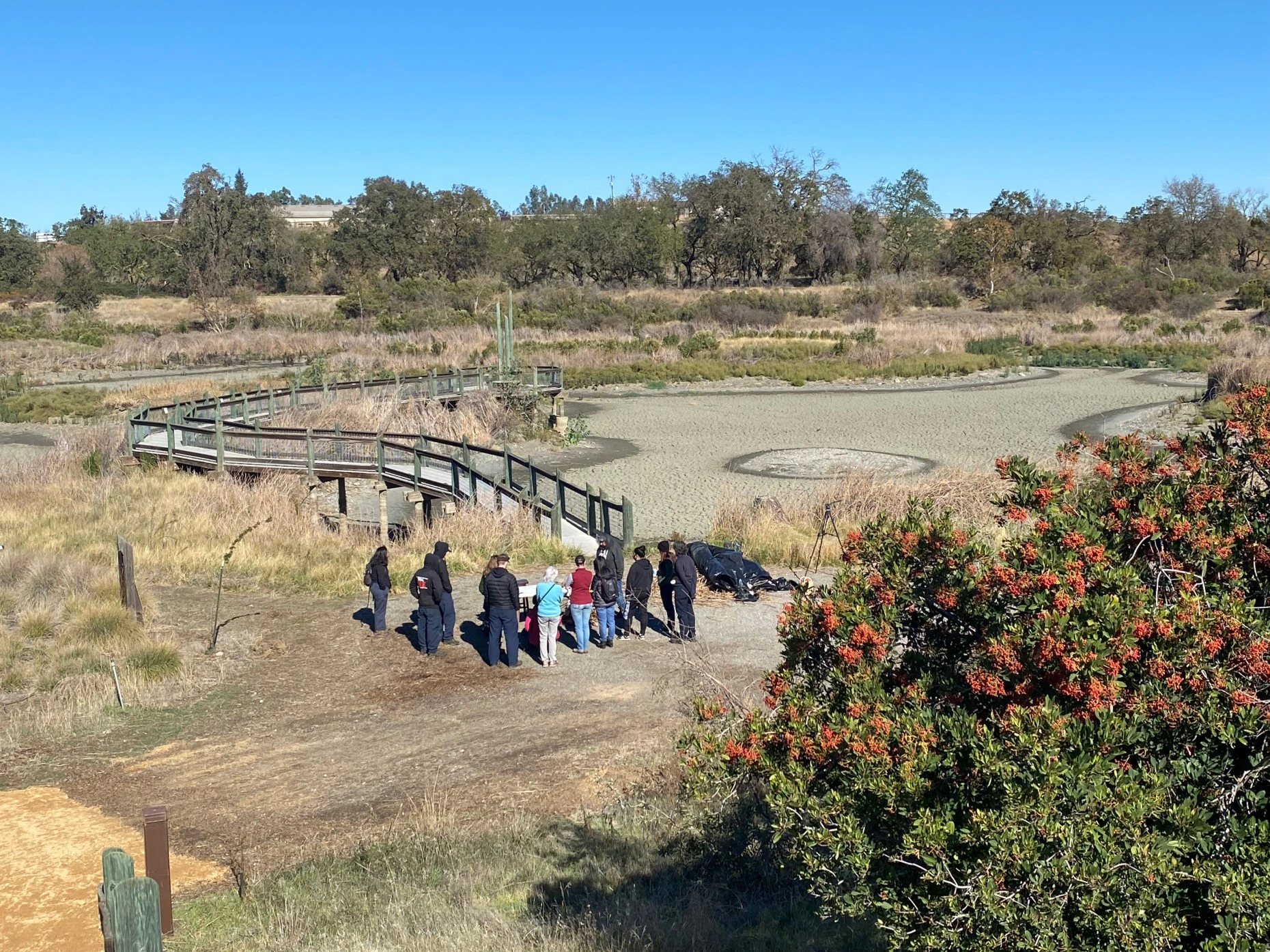 Firefighters and others gather near the now empty Cache Creek Conservancy pond to learn about 